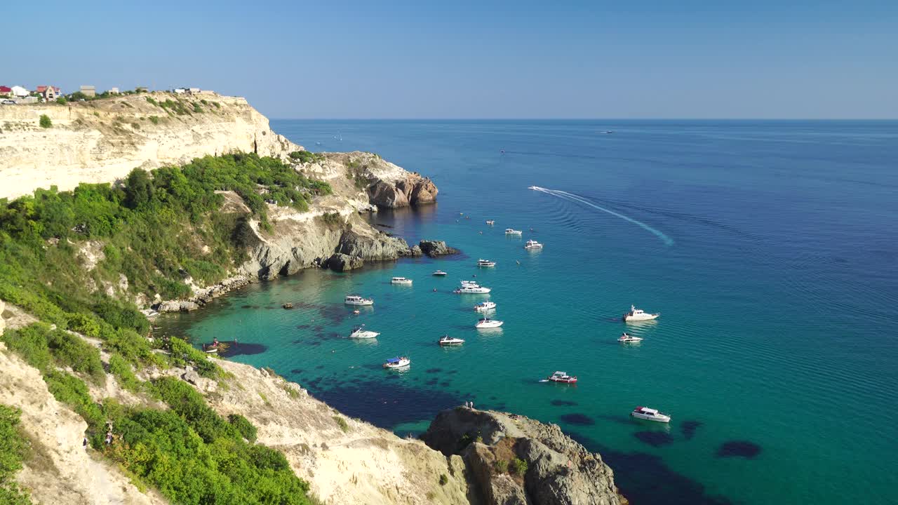 小船和游艇在蔚蓝的大海上。鸟瞰图的山脉和岩石的海景。未开发的自然，干净的水。岩石海岸和隐藏的海滩。夏季旅游和休息的理想场所视频素材