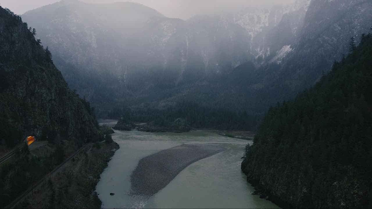 飞越以巨大山脉为背景的转弯河流视频素材