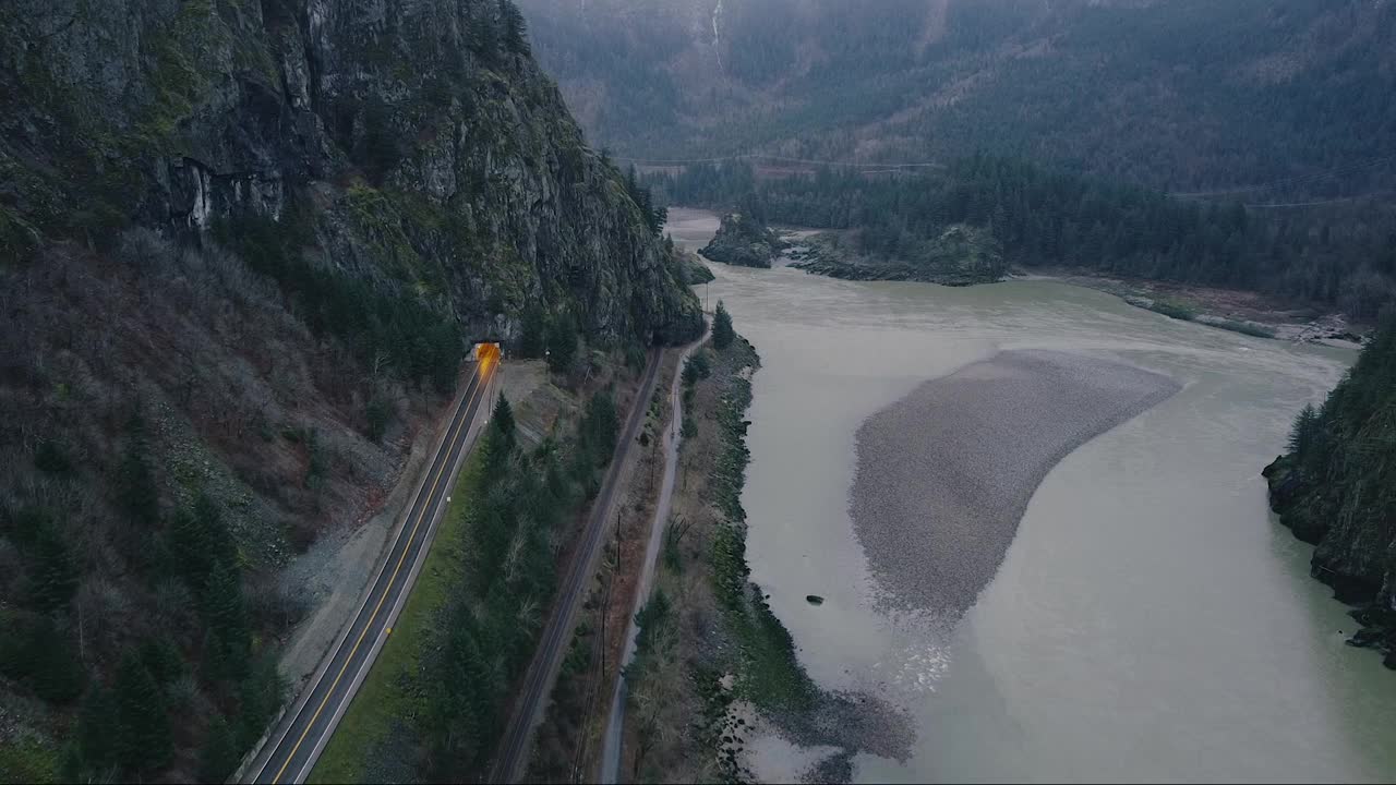 鸟瞰图铁路进入隧道和一条小路与巨大的山前面视频素材