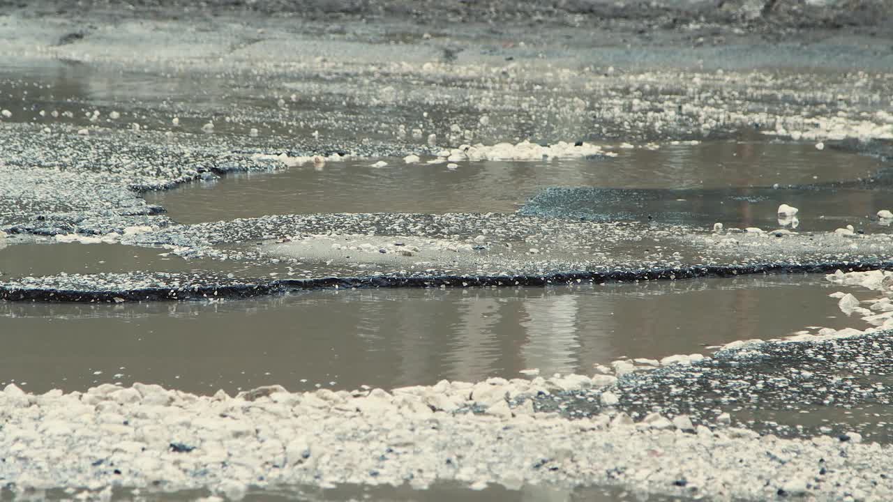 雨后深坑，严重破坏了道路基础设施。视频素材