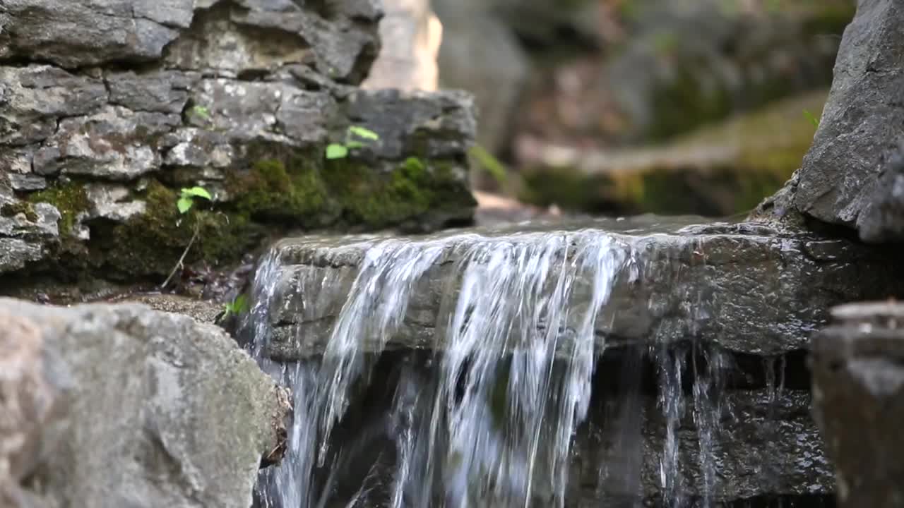 瀑布与清澈的水在岩石河流动视频素材