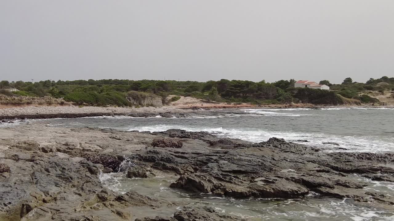 右平移暗示性的岩石荒野海湾与海浪撞击海岸视频素材