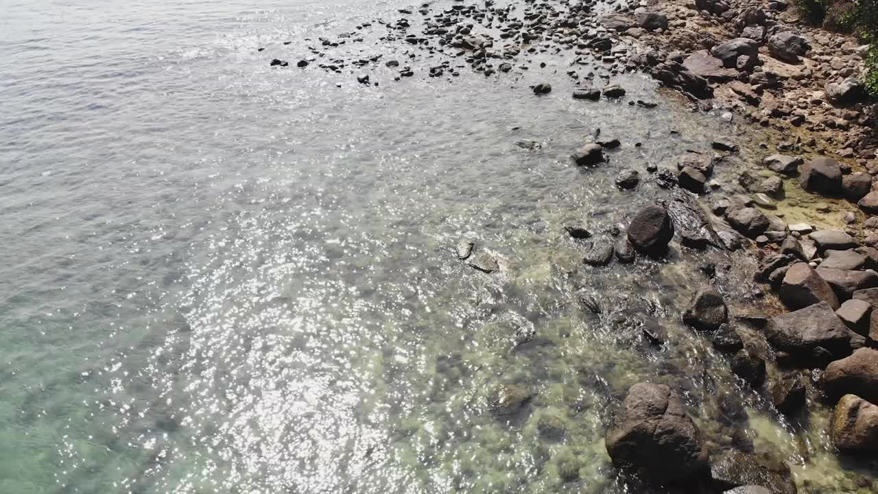 海浪鞭笞线冲击岩石上的海滩，鸟瞰石头和大海视频素材