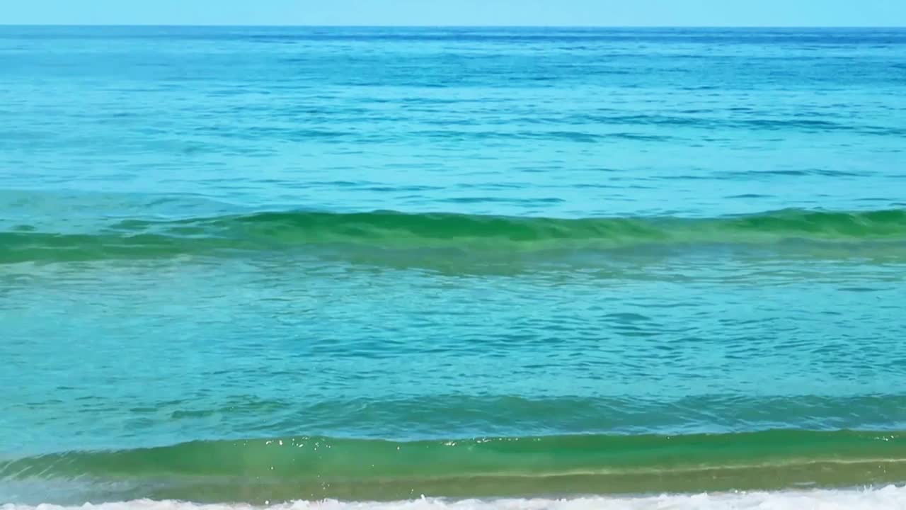 海浪青色的海水与白色泡沫在蓝色的天空视频素材