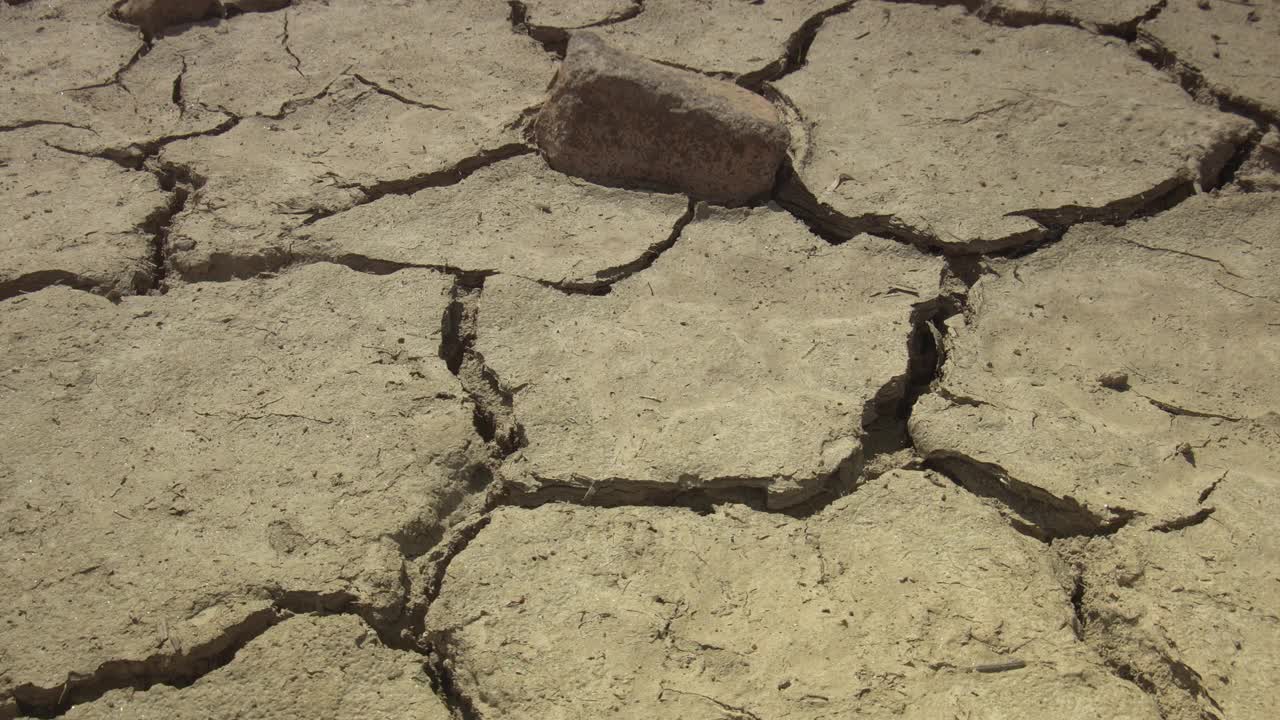 特写破碎的地面由干旱的夏季炎热干燥的土壤在变暖危机中显示全球缺水的星球和气候变化视频素材