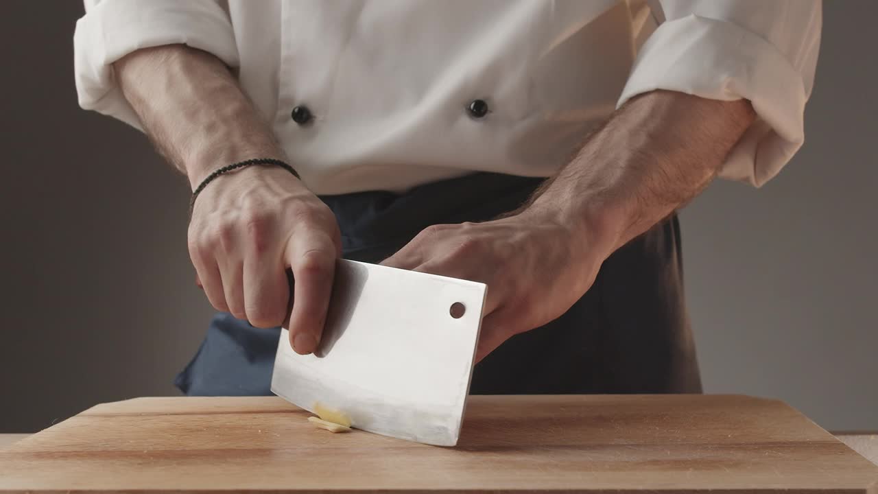 在厨房里用大刀切生姜的人准备食物视频素材