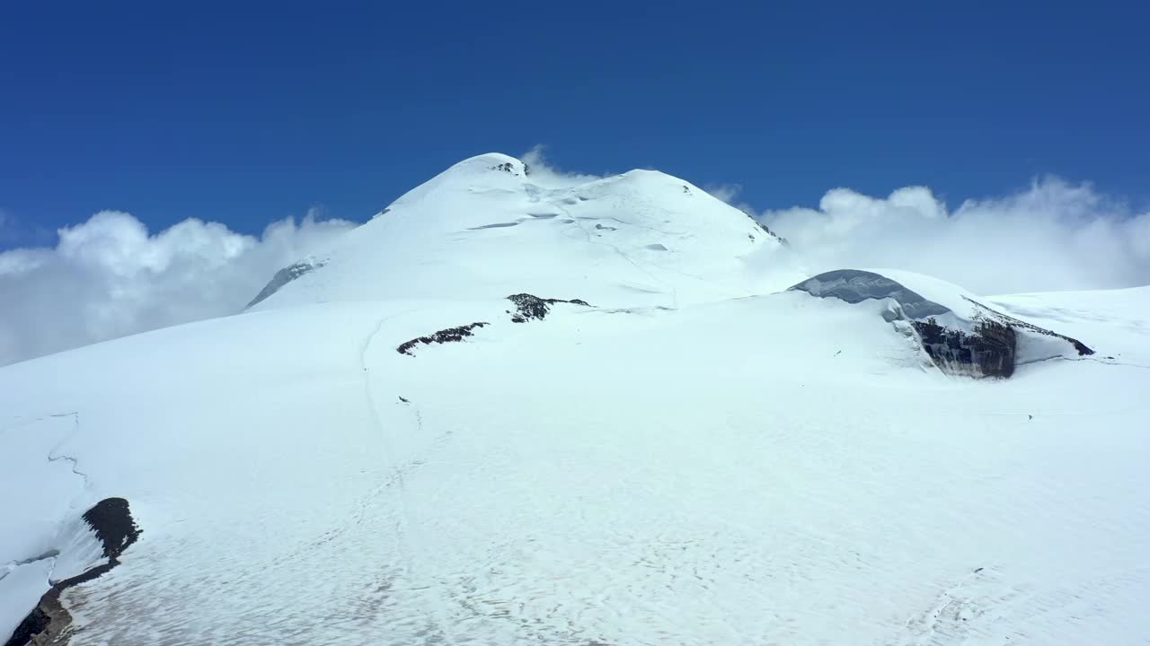 蓝天映衬着山顶，积雪覆盖。视频素材