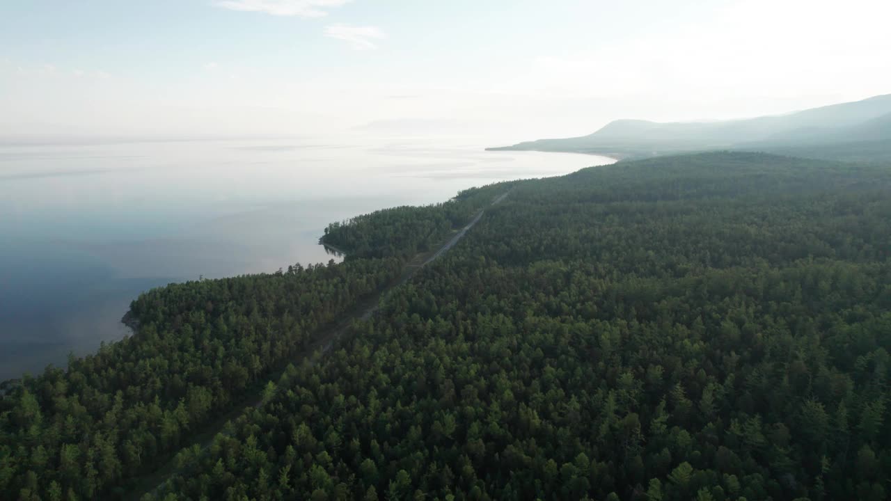 史诗般的贝加尔湖清晨鸟瞰图。山上森林湖碧绿的水，有松树。鸟瞰蓝色的湖泊和绿色的森林。山间森林间的湖景。视频素材