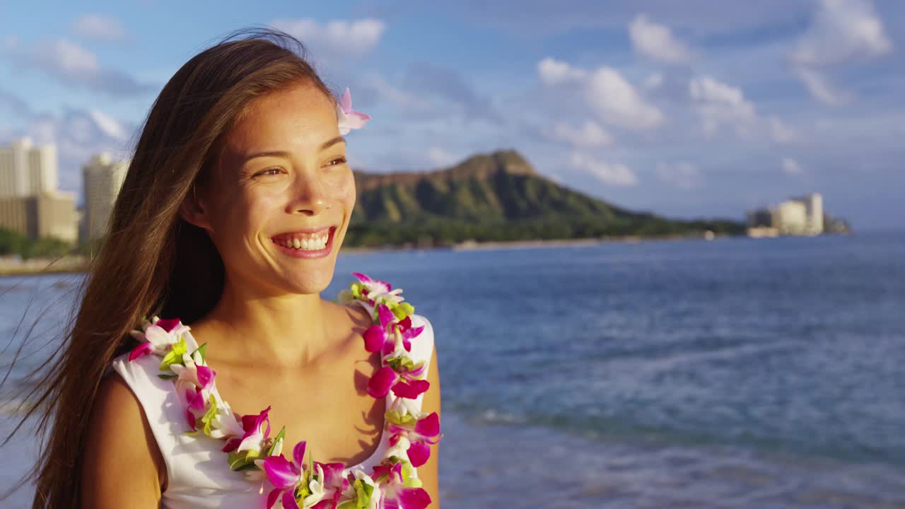 夏威夷旅游海滩假期-妇女微笑快乐穿着传统的夏威夷花蕾。沙滩度假胜地的混血亚裔白种人女人。，威基基，瓦胡岛，美国夏威夷。视频素材