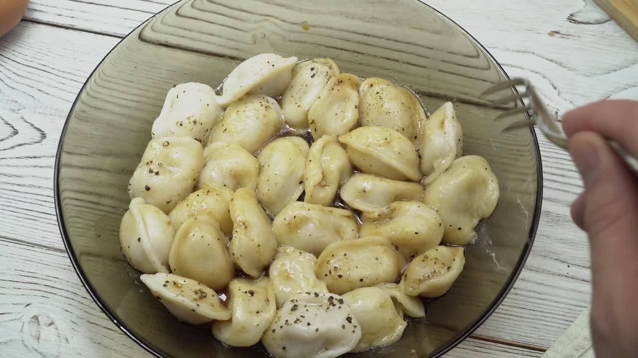 传统的俄罗斯饺子，馄饨，木制背景上的肉饺子。设计和食品造型的想法出售。家常菜餐厅，菜单或烹饪书的概念。4 k的片段视频下载