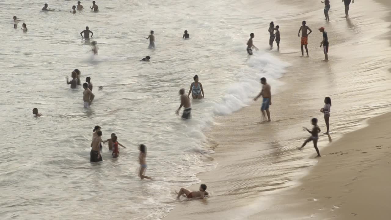 人们在繁忙的PaciÃªncia海滩的里约热内卢Vermelho附近的海浪中跳跃。视频下载