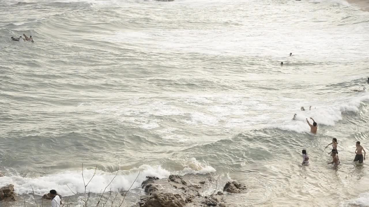 人们在繁忙的PaciÃªncia海滩的里约热内卢Vermelho附近的海浪中跳跃。视频下载