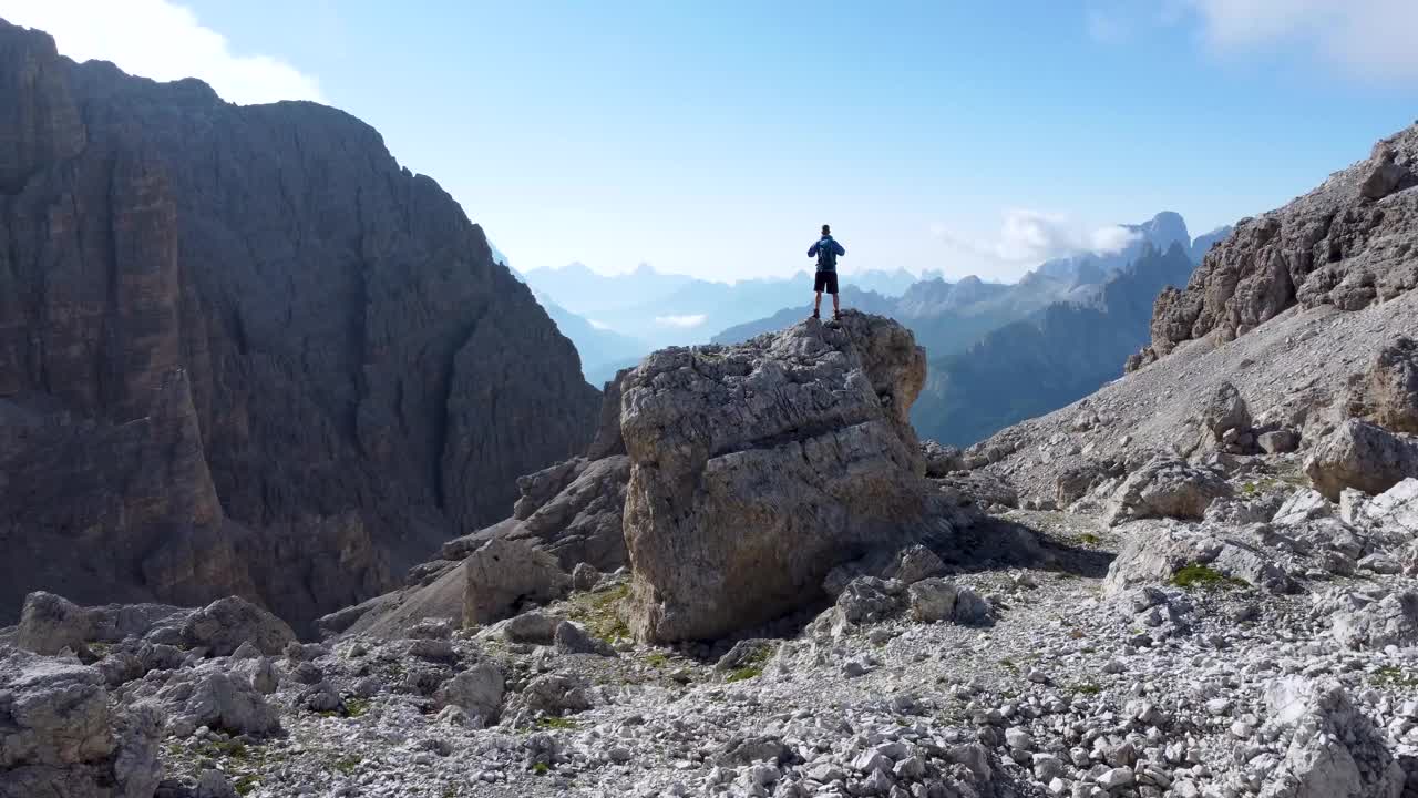 一个徒步旅行者在山顶高兴地举起双臂视频素材