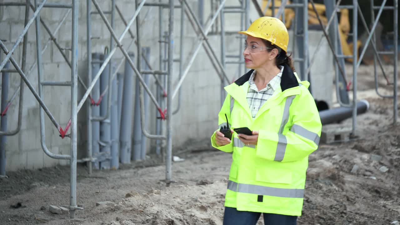 建筑工地上的西班牙女人，把数据存入手机视频素材