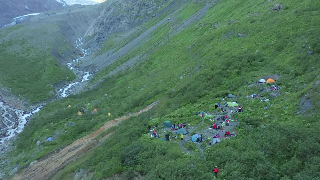 山河附近的游客帐篷鸟瞰图。在低地种植植物的山地旅游营地。视频素材