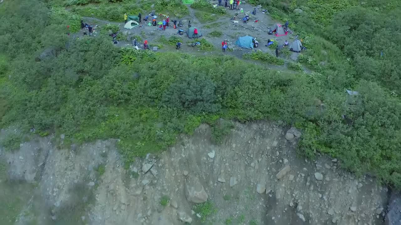 经过一天的辛苦跋涉，人们准备在晚上睡觉。登山队员用帐篷扎营视频素材