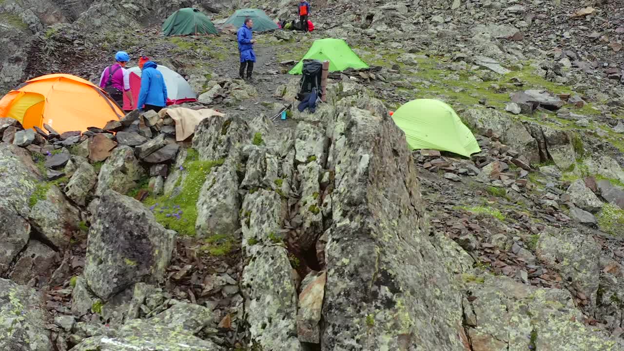 在陡峭的悬崖上搭有登山队员帐篷的帐篷。游客营地的鸟瞰图视频素材