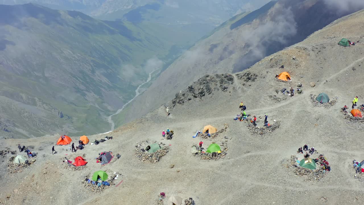 山徒步旅行。鸟瞰图营地与游客在高山上。视频素材