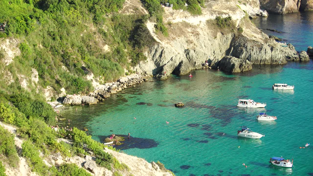 小船和游艇在蔚蓝的大海上。鸟瞰图的山脉和岩石的海景。未开发的自然，干净的水。岩石海岸和隐藏的海滩。夏季旅游和休息的理想场所视频素材