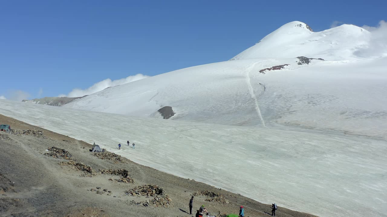 三名登山者从山上爬到突击营地后沿着冰川返回，他们的朋友向他们问候并祝贺视频素材