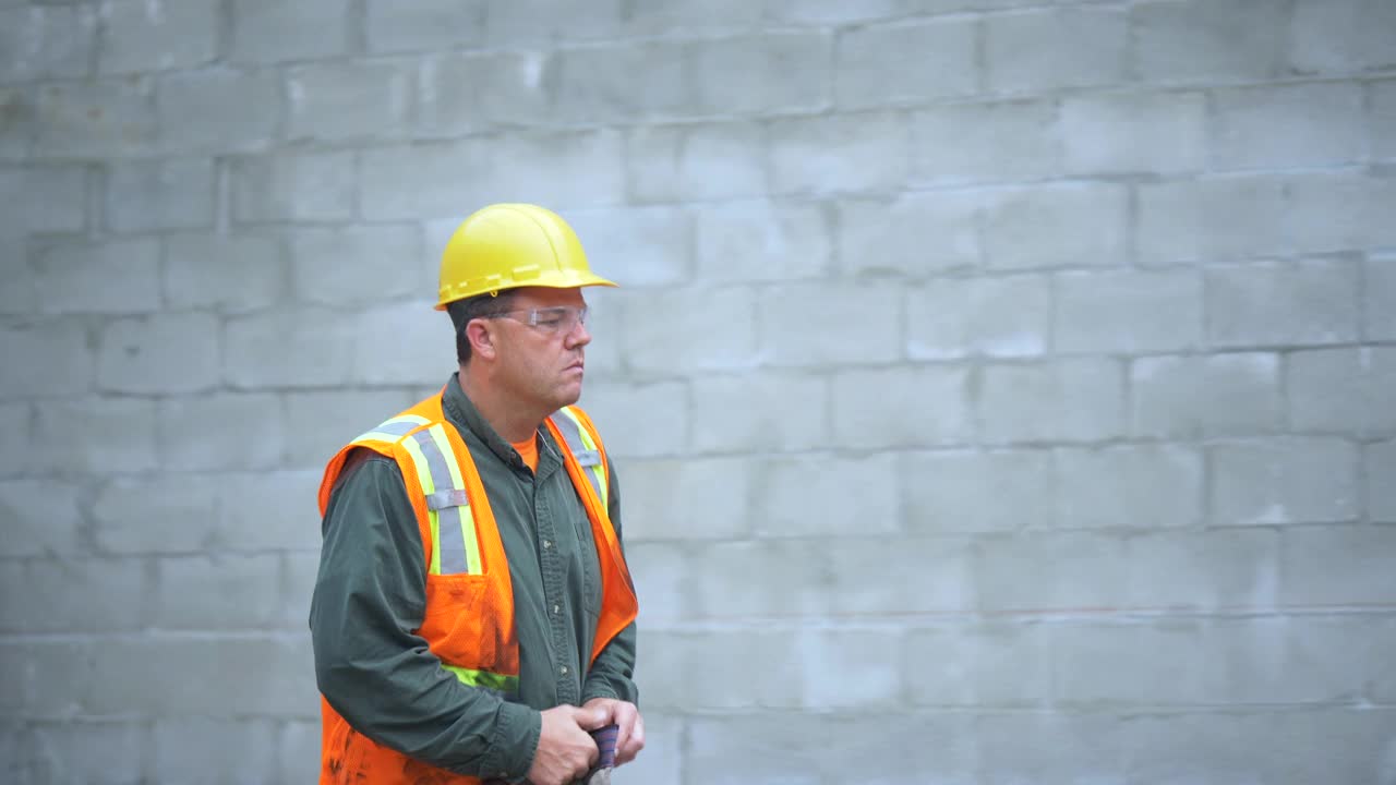 一名西班牙男子走过建筑工地的砖墙视频素材