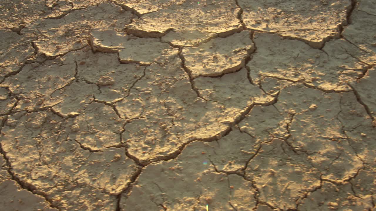 特写破碎的地面由干旱的夏季炎热干燥的土壤在变暖危机中显示全球缺水的星球和气候变化视频素材