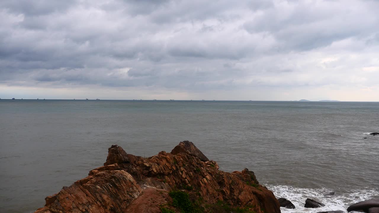 4k波光粼粼的海洋海水海浪表面和海岸岩石海岸云朵云景。视频素材