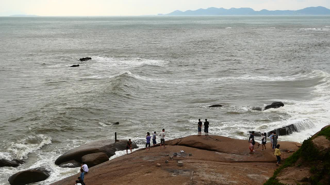 4k人看到波光粼粼的大海波涛汹涌的海浪拍打着岩石。沿海海岸。视频素材