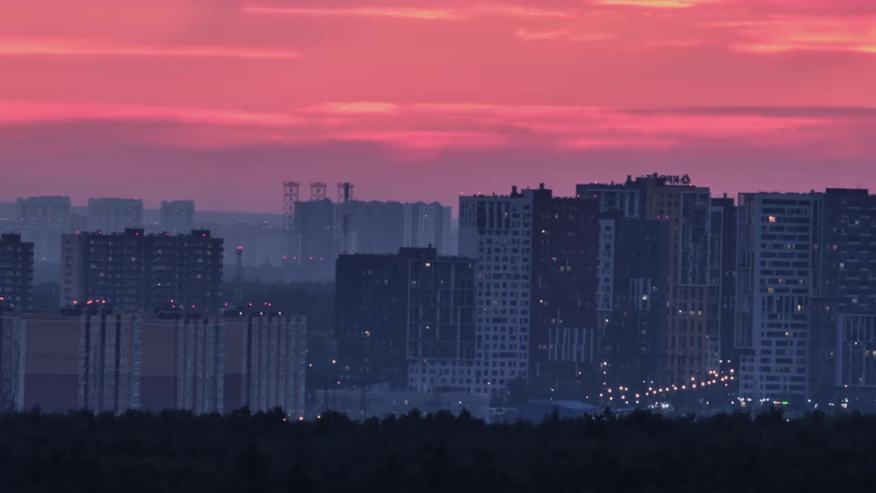 夜幕降临，城市灯火夕照，房子上空红彤彤的视频素材