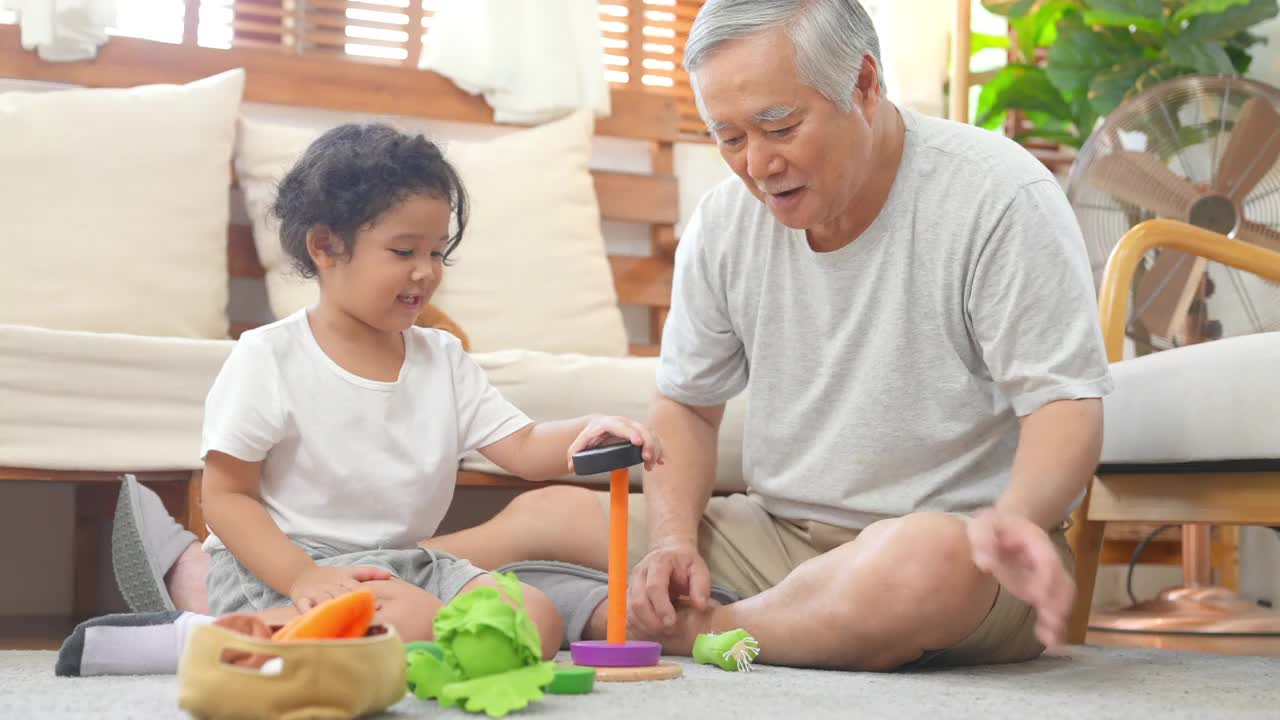 爷爷和小孙女在家里客厅里玩得很开心视频素材