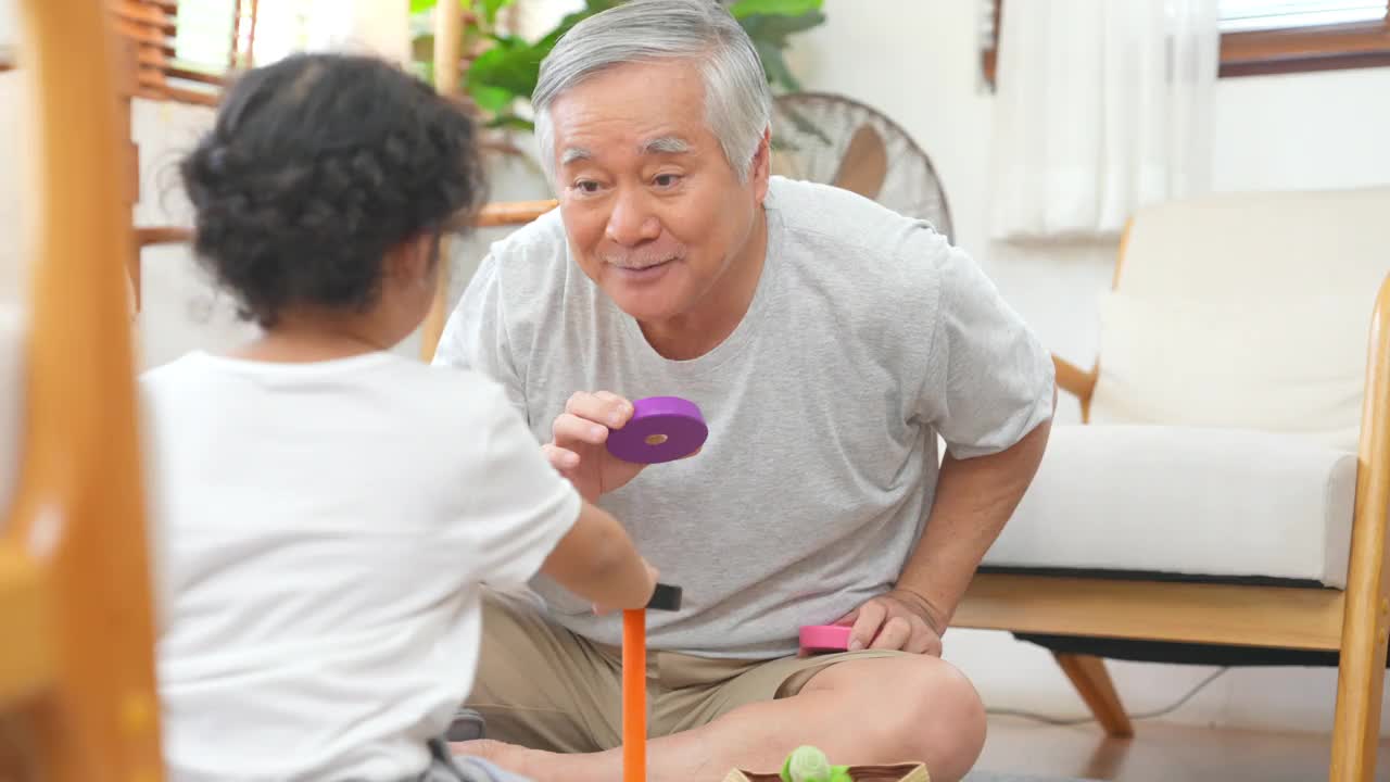 爷爷和小孙女在家里客厅里玩得很开心视频素材