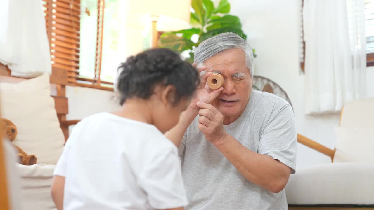 爷爷和小孙女在家里客厅里玩得很开心视频素材