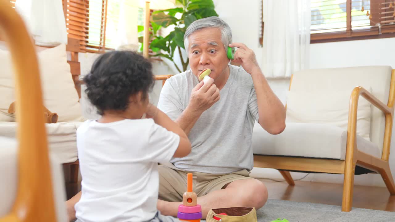 爷爷和小孙女在家里客厅里玩得很开心视频素材