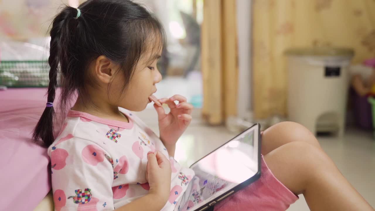 小女孩在房间里用药片吃零食视频素材