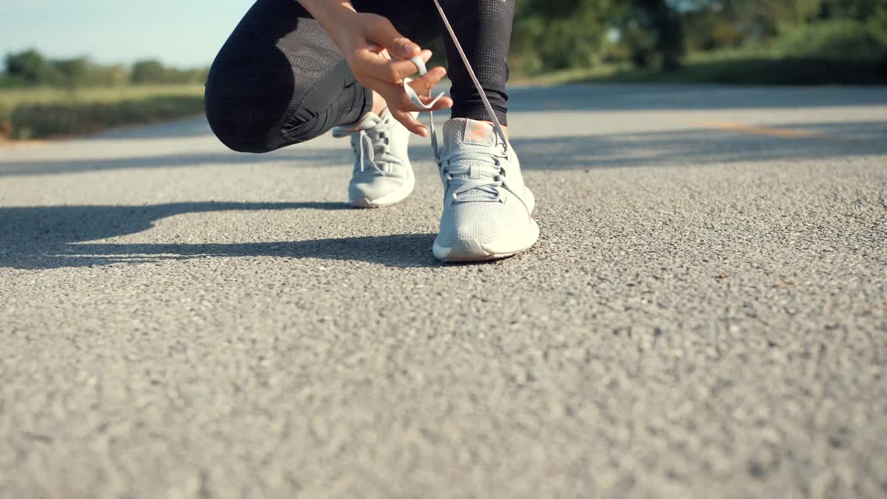 女人在跑步鞋上系鞋带视频素材