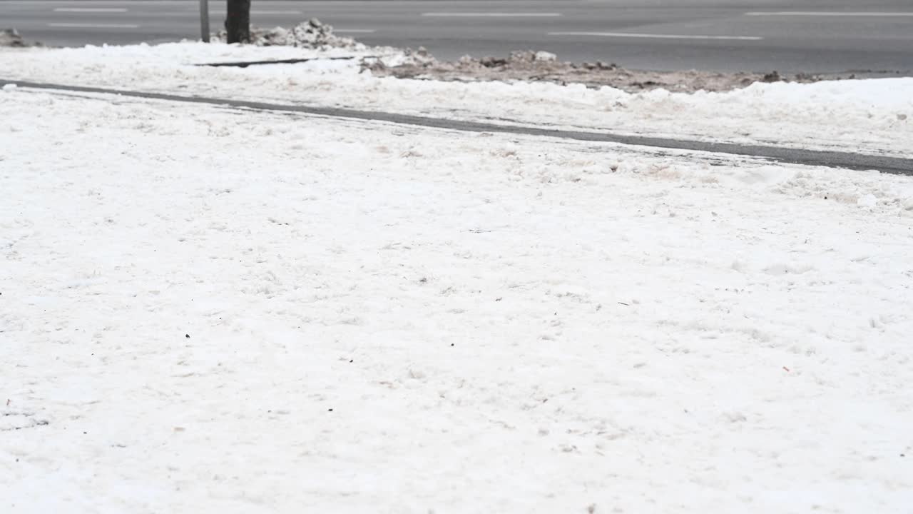 一个人骑着他的自行车在城市的自行车道，已经部分清除积雪，使骑车成为可能。德国。视频素材