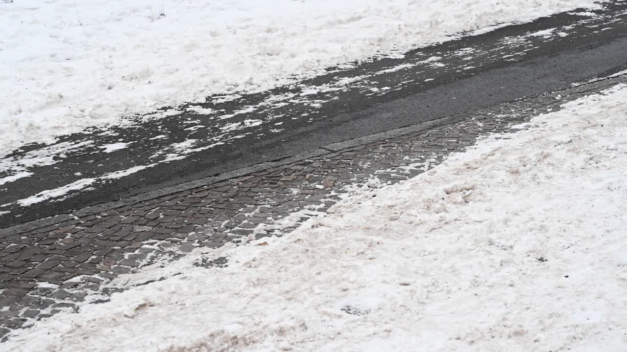 一个人骑着他的自行车在城市的自行车道，已经部分清除积雪，使骑车成为可能。德国。视频素材