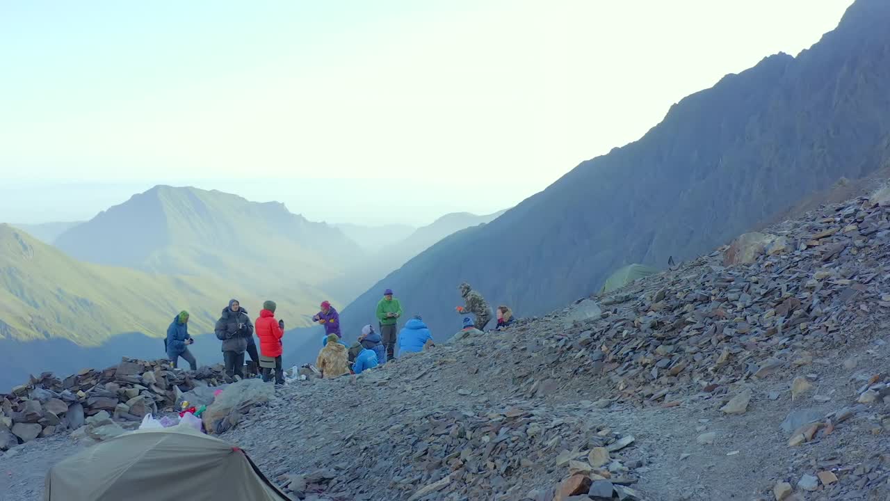 登山运动员在艰难的登山前在岩石上吃早餐。视频素材