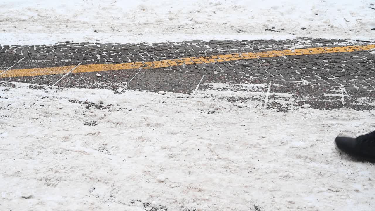 一个人走在城市的自行车道附近，那里已经部分清除了积雪，可以骑车了。德国。视频素材