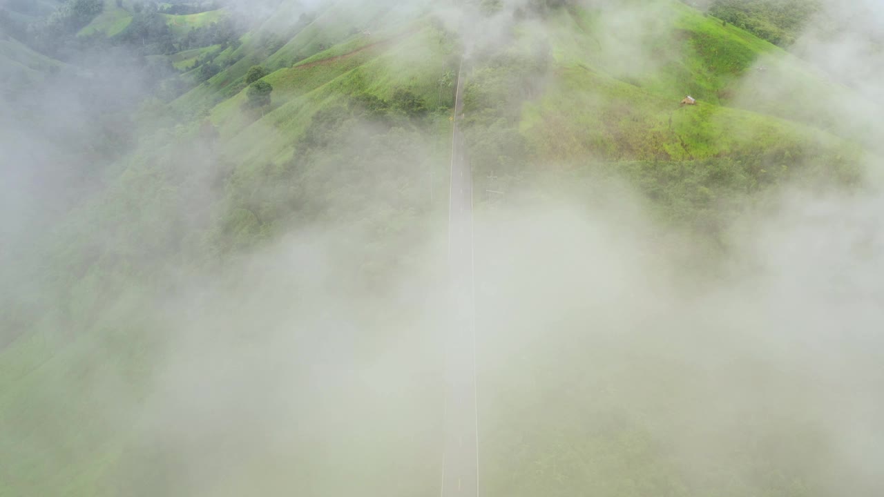 鸟瞰图的乡村道路通过郁郁葱葱的绿叶和热带雨林山区景观，泰国北部，南省。视频素材