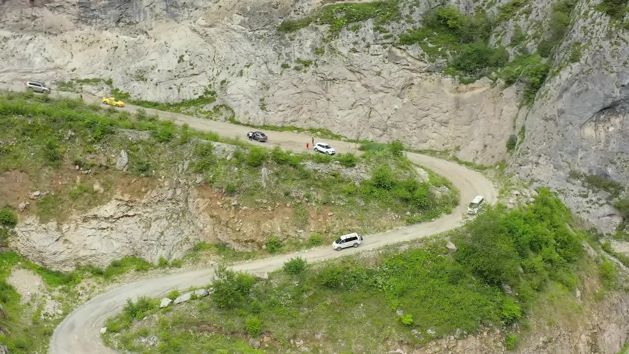 陡峭的山路蜿蜒曲折，汽车在路上行驶。视频素材