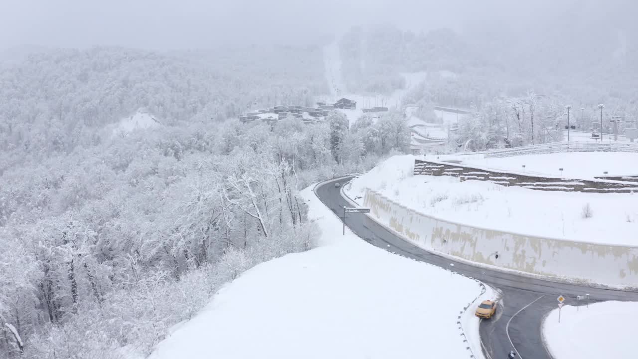 鸟瞰图冬季飞行滑雪场建筑与高速公路交通索道风景如画视频素材