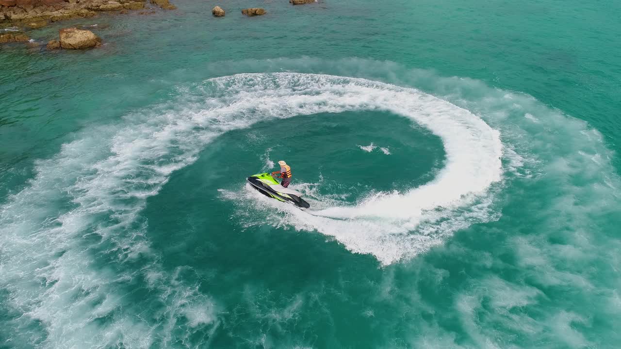 人们在海里玩水上摩托艇。鸟瞰图。前视图。神奇的自然背景。水的颜色又美又亮。新鲜的自由。冒险的一天。热带海滩上清晰的蓝绿色。视频素材