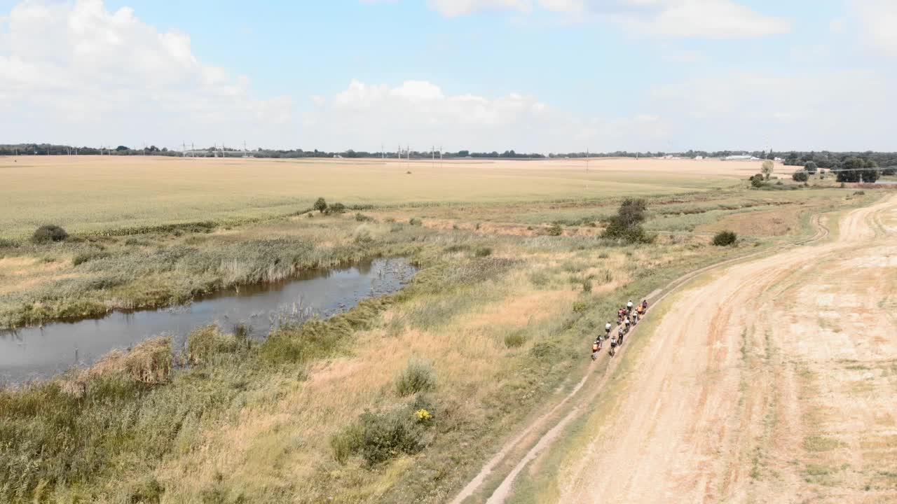 在乡间小路上骑着砂石自行车的自行车手。砾石自行车冒险。旅行者在大自然中骑自行车。砾石骑自行车。朋友一起骑自行车视频素材