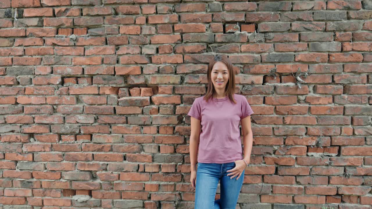 一个站在砖墙旁的日本女人视频素材