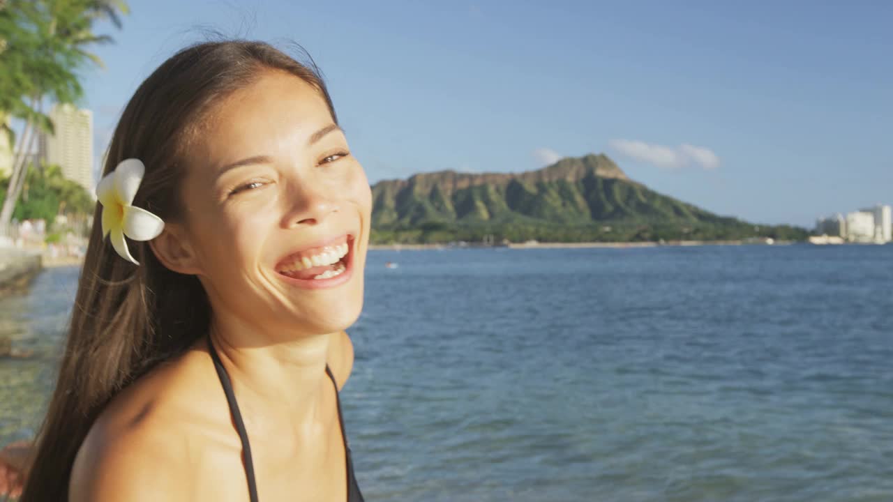 海滩女人笑着笑着在夏威夷的怀基基海滩上玩比基尼。夏威夷海滩的女孩。美丽的混血亚洲白种人女孩黑发有乐趣笑和享受日落。瓦胡岛,夏威夷,美国视频素材