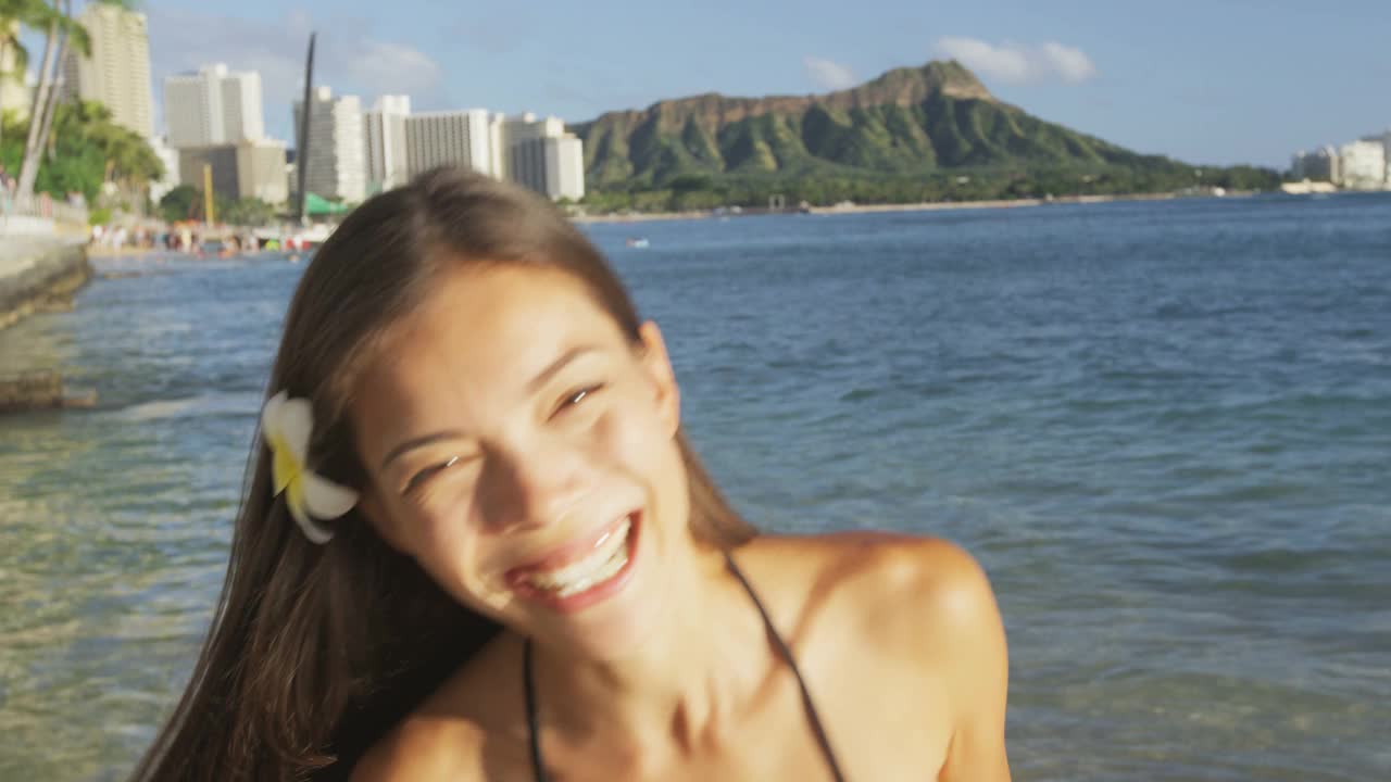 海滩女孩笑着笑着在夏威夷的怀基基海滩上玩比基尼。夏威夷海滩的女人。美丽的混血亚洲白种人女孩黑发有乐趣笑和享受日落。瓦胡岛,夏威夷,美国视频素材