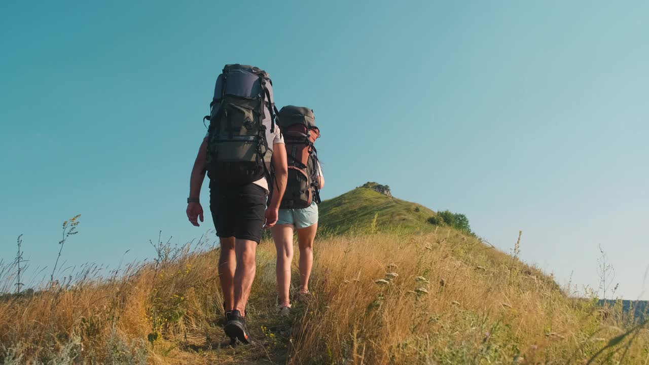 一男一女背着背包徒步旅行。慢动作视频素材