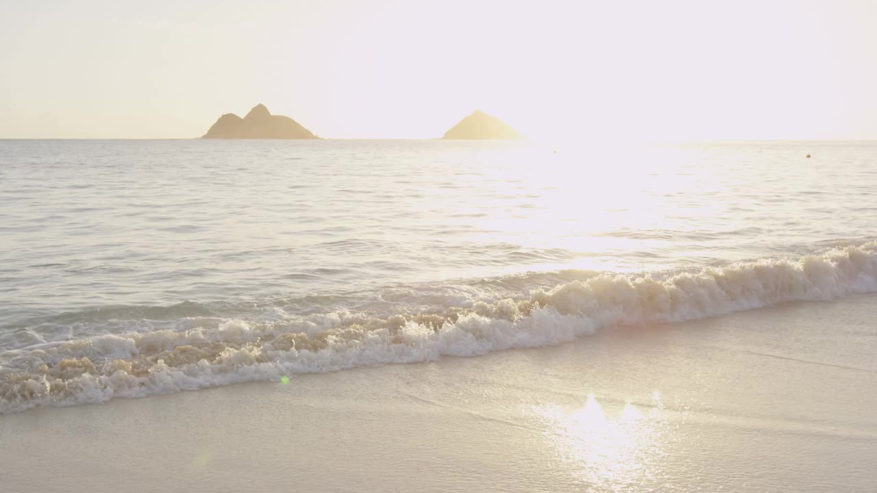 情侣手牵着手在海滩上享受日落的蜜月旅行。幸福浪漫的年轻情侣，男女漫步在美丽的海滩上。美国夏威夷瓦胡岛拉尼凯海滩。红色的慢动作。视频素材