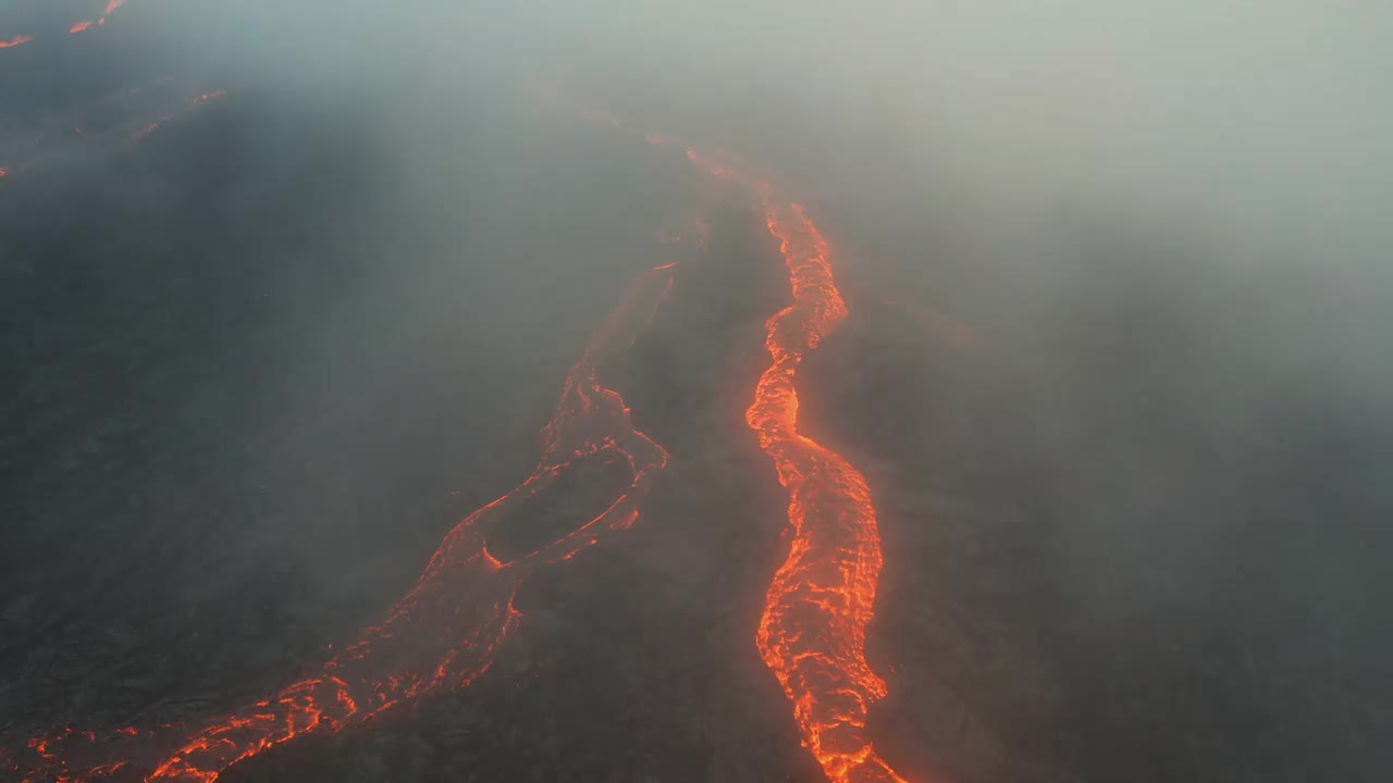 在冰岛雷克雅斯半岛的法格拉达斯火山，无人机拍摄的穿过低空云层的熔岩河视频素材